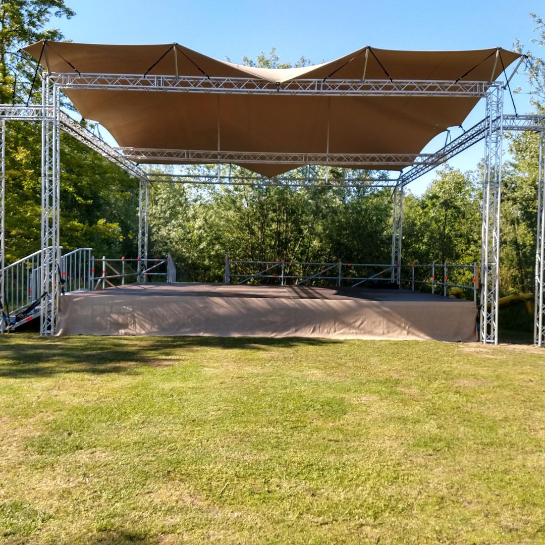 Creatief podium met zandkleurige stretchtent overkapping en jute afwerking bij de Verbeeck Foundation